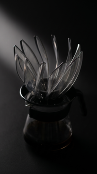 Flower Cone Dripper head-on, clear petals open above the black holder plate